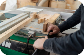Carpenter cutting timber on a workshop machine