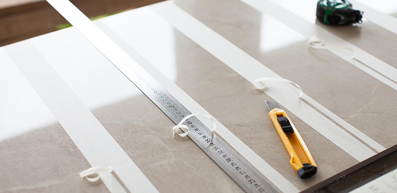 Measuring and cutting a cabinet panel with a ruler and craft knife